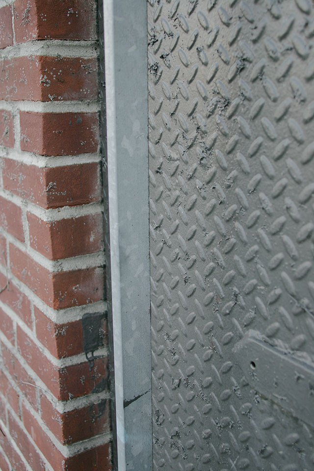 Grey painted steel doors with elongated modern hardware.